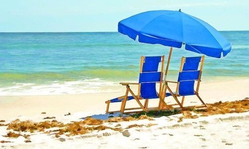 Two Blue Chairs and Umbrella on Beach